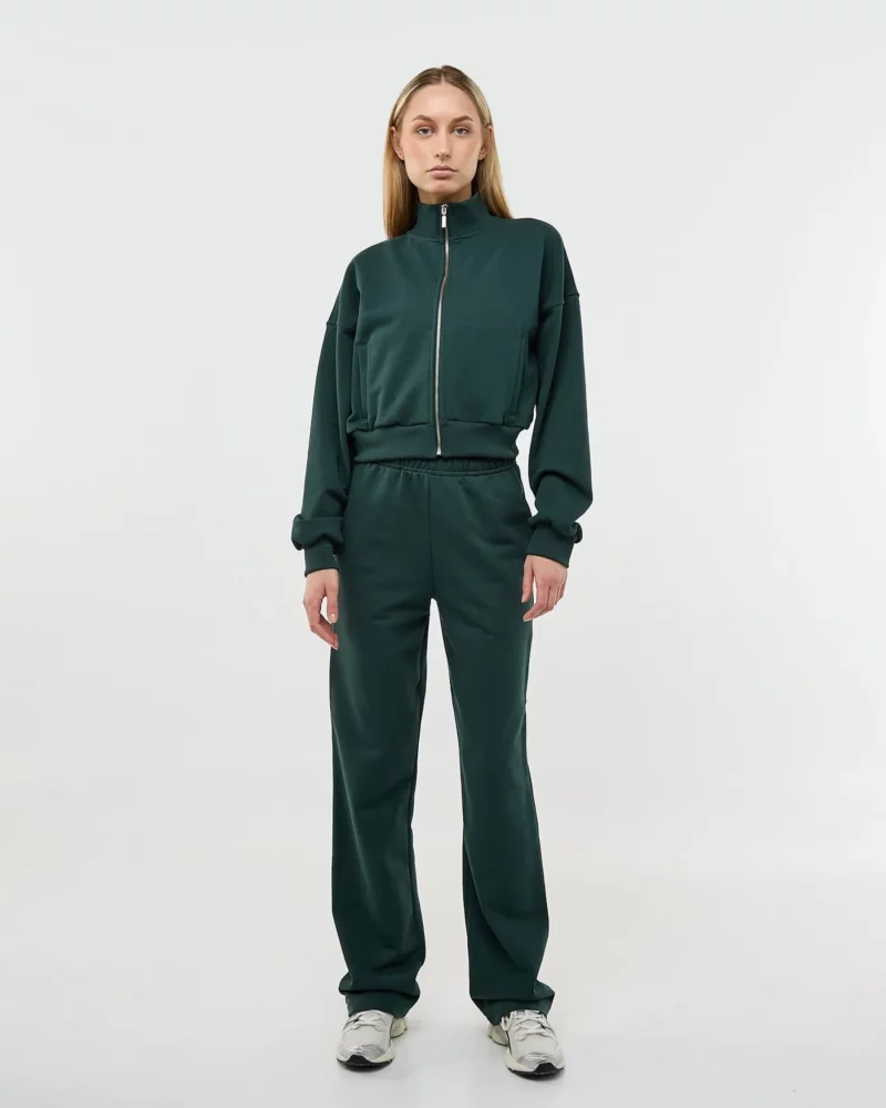 Mergina dėvi tamsiai žalią laisvalaikio kostiumėlį