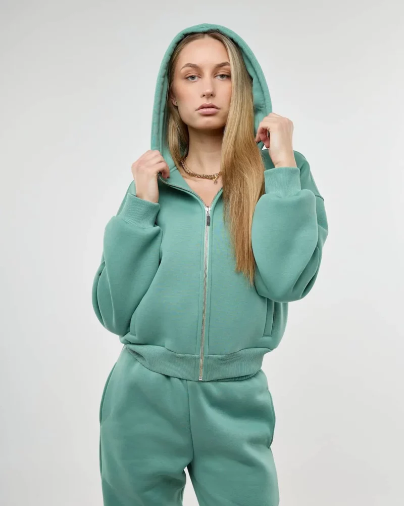 Šviesiaplaukė mergina vilki džemperį su kapišonu ir užtrauktuku