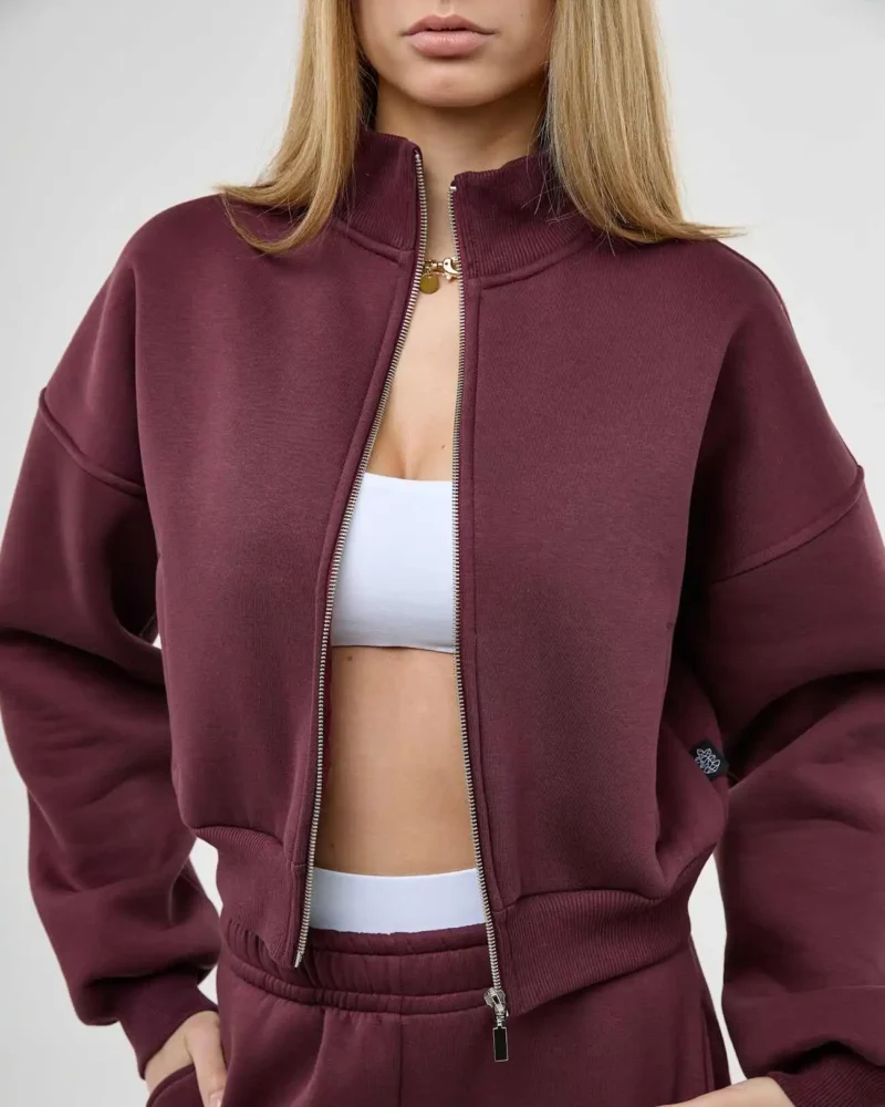 Mergina vilki burgundiškos spalvos džemperį su prasegtu užtrauktuku