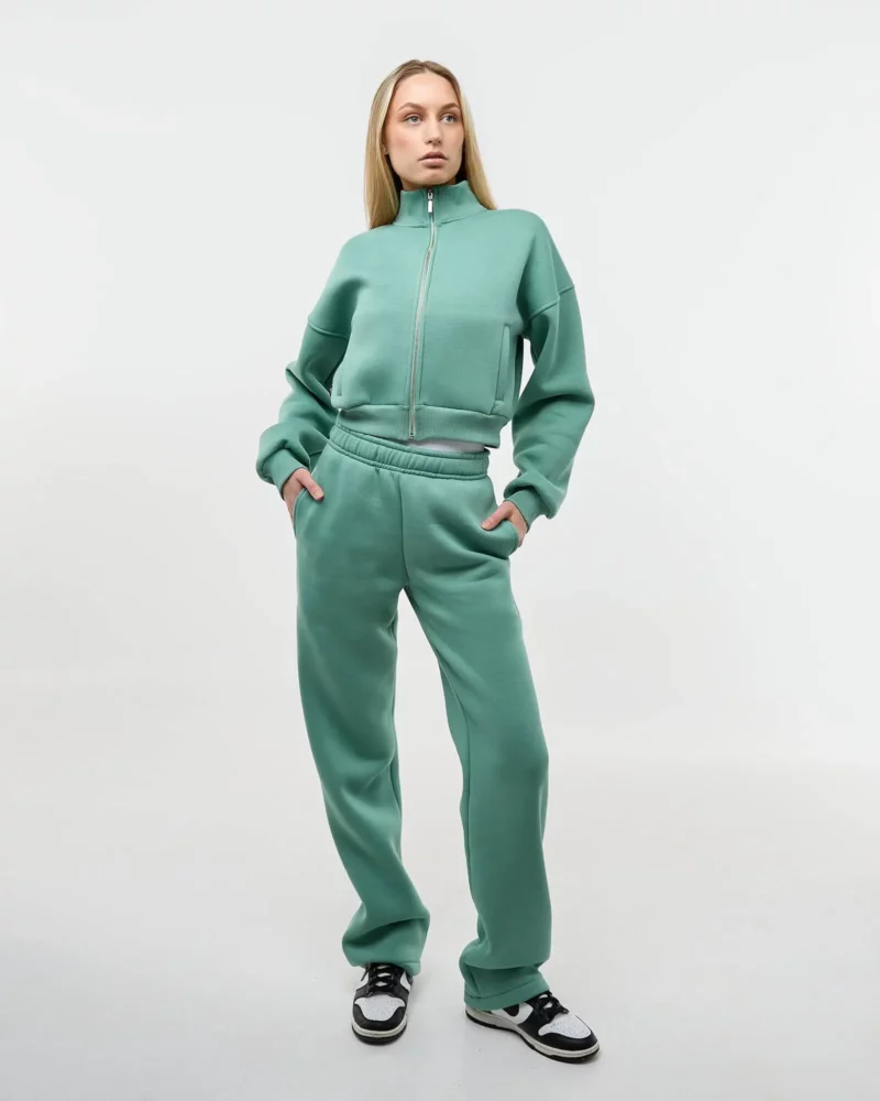 Šviesiaplaukė mergina dėvi šviesiai žalsvą laisvalaikio kostiumėlį sage moss