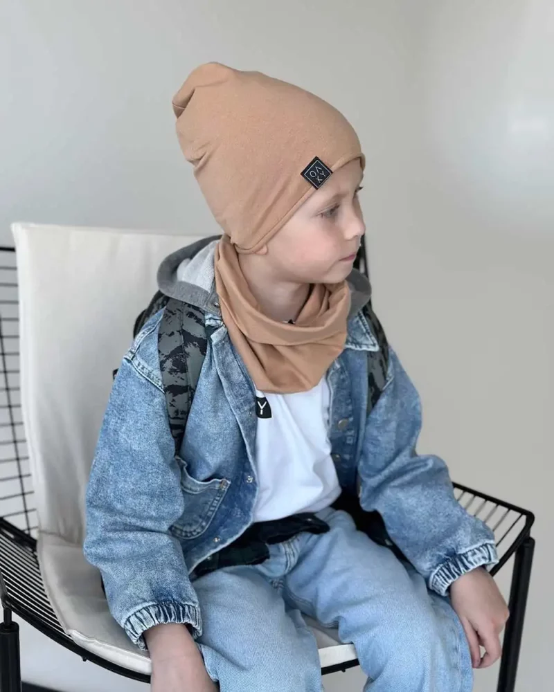 Berniukas dėvi ploną kepurę su mova camel spalvos