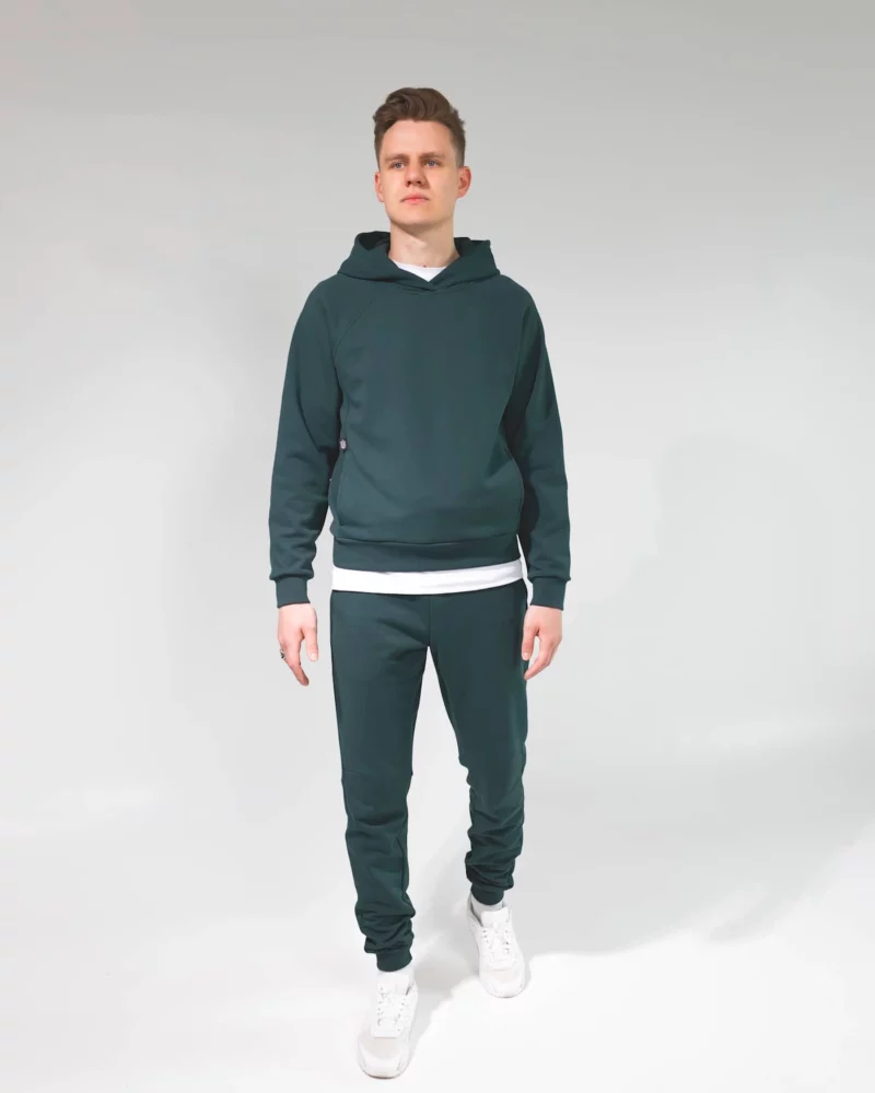 Vaikinas dėvi tamsiai žalią laisvalaikio kostiumą